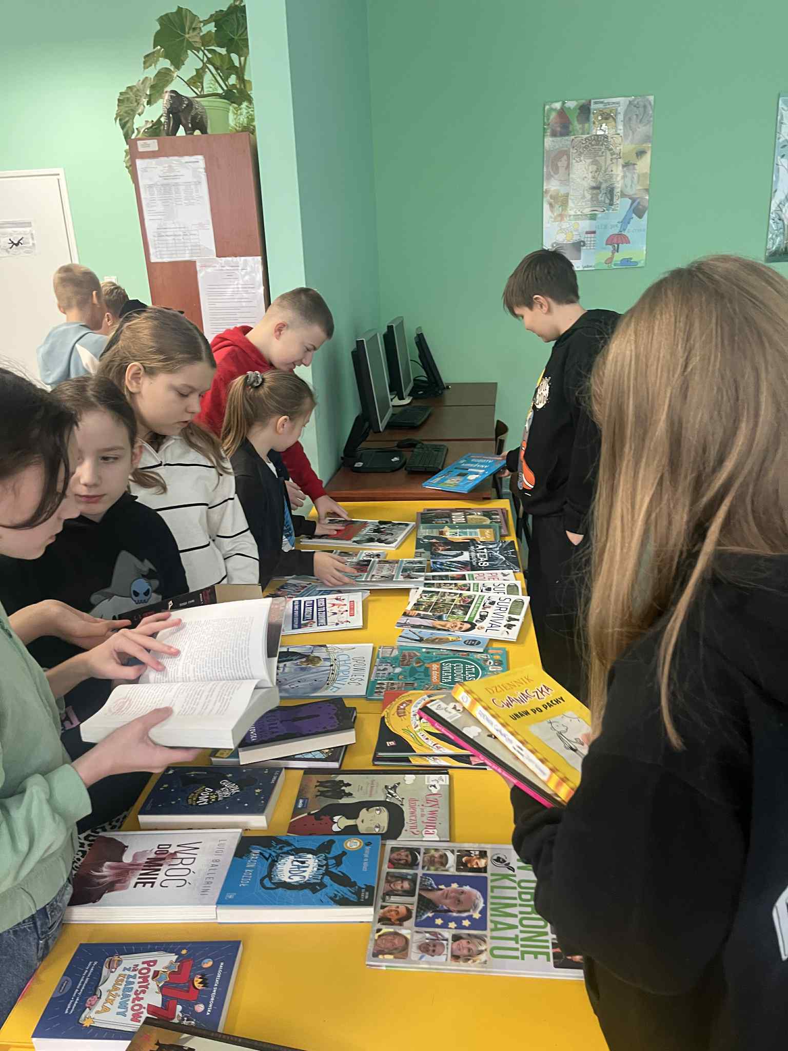 uczniowie stoją przy stolikach