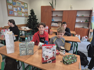 Uczniowie rozpakowują mikołajkowe prezenty.