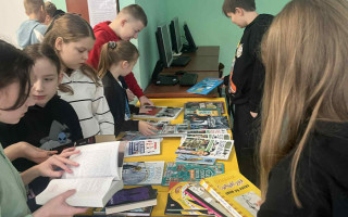 uczniowie oglądają książki