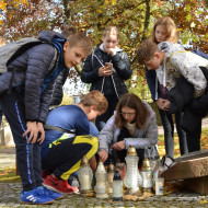 Uczniowie zapalają znicz przy grobie Stefana Artwińskiego na Cmentarzu Starym.