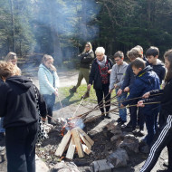 Klasy 5a i 6a pieką kiełbaski przy ognisku.