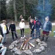 Klasa 5b wokół ogniska piecze kiełbaski.