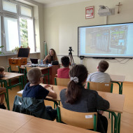 Uczniowie klasy piątej oraz edukator z Laboratoriów Przyszłości w sali lekcyjne.