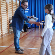 Pan dyrektor wręcza uczennicy nagrodę.