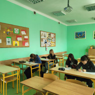 Uczennice w skupieniu rozwiązują zadania egzaminacyjne.