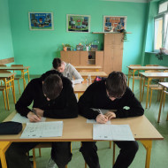 Trzej chłopcy rozwiązują zadania.