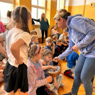 Nauczycielka rozdaje dzieciom cukierki