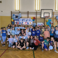 Wspólne zdjęcie uczniów i nauczycieli na tle napisu NIEBIESKIE IGRZYSKA.