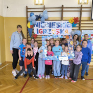Grupa dzieci wraz z nauczycielkami uśmiechają się do zdjęcia