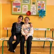 Dwie dziewczynki siedzą na ławeczce przyjaźni