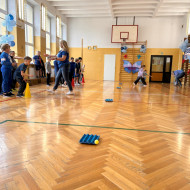 Dzieci z odległości rzucają piłeczką do wytłaczanki po jajkach