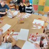 Przedszkolaki układają puzzle patriotyczne