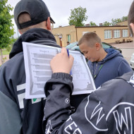 Uczeń rozwiązuje zadania na karcie pracy położonej na plecach kolegi.