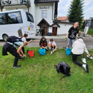 Uczniowie przed pensjonatem czyszczą buty po górskiej wyprawie.