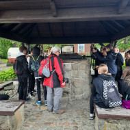Uczniowie z przewodnikiem przy studni na rynku w Krościenku.