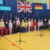 Grupa przedszkolaków śpiewa piosenkę.