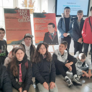 Uczniowie w holu muzeum przy plakatach promujących wystawę o Niziurskim.