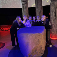 Uczennice stoją przy wielkim głazie w Parku Legend.