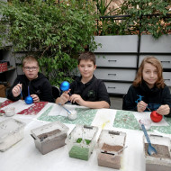 Uczniowie trzymają w dłoniach bombki, które za chwilę będą ozdabiać