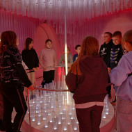 Uczniowie znajdują się w Pokoju Świateł- jednego z etapów ścieżki edukacyjnej Żywego Muzeum Bombki, słuchają historii opowiadanej przez przewodnika