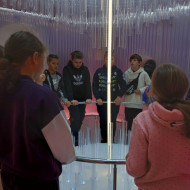 Uczniowie znajdują się w Pokoju Świateł- jednego z etapów ścieżki edukacyjnej Żywego Muzeum Bombki, słuchają historii opowiadanej przez przewodnika