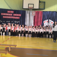 Przedszkolaki wraz z prowadzącymi apel uczennicami klas 8 śpiewają hymn.