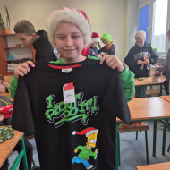 Uczeń prezentuje koszulkę świąteczną - mikołajkowy prezent,