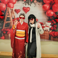 Dwie uczennice w oryginalnych strojach na tle walentynkowej ścianki. 