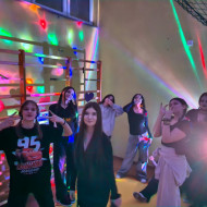 Uczennice tańczące podczas dyskoteki w sali gimnastycznej.