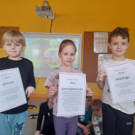 Przedszkolaki prezentują plansze ze zwrotami grzecznościowymi.