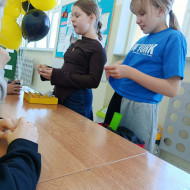 Uczennice stoją przy stolikach