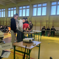 uczniowie stoją przy stoliku