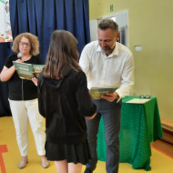 Pan dyrektor wręcza nagrodę uczennicy.