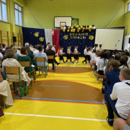 Sala gimnastyczna w szkole, przedszkolaki tańczą poloneza