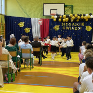 Sala gimnastyczna w szkole, przedszkolaki tańczą poloneza