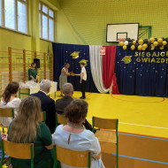 Sala gimnastyczna w szkole, uczeń odbiera nagrodę