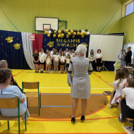 Sala gimnastyczna w szkole, chór śpiewa
