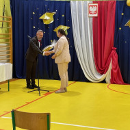 Sala gimnastyczna w szkole, dyrektor wręcza nagrodę