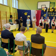 Sala gimnastyczna w szkole, uczeń wpisuje się w pamiątkowej kronice