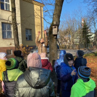 Uczniowie dokarmiają ptaki w szkolnym ogrodzie