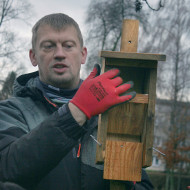 Pan przyrodnik pokazuje jak wygląda w środku domek dla nietoperzy – półeczka w środku