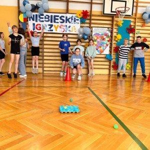 Dzieci z odległości rzucają piłeczką do wytłaczanki po jajkach