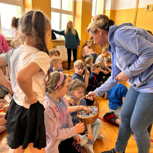 Nauczycielka rozdaje dzieciom cukierki