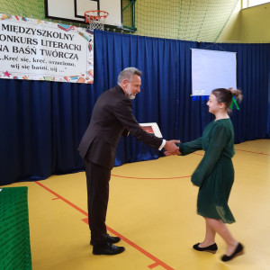 Pan dyrektor wręcza nagrodę uczennicy.