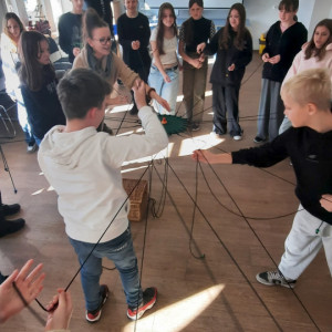 Uczniowie rozciągają sznurki tarczy współoracy.