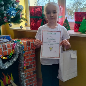 Uczennica z dyplomem i nagrodą.