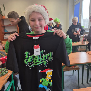 Uczeń prezentuje koszulkę świąteczną - mikołajkowy prezent,