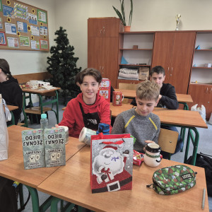 Uczniowie rozpakowują mikołajkowe prezenty.