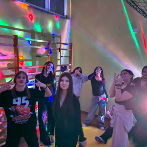 Uczennice tańczące podczas dyskoteki w sali gimnastycznej.