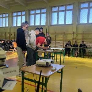 uczniowie stoją przy stoliku